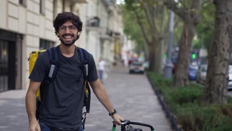 super positive courier with backpack on a bike