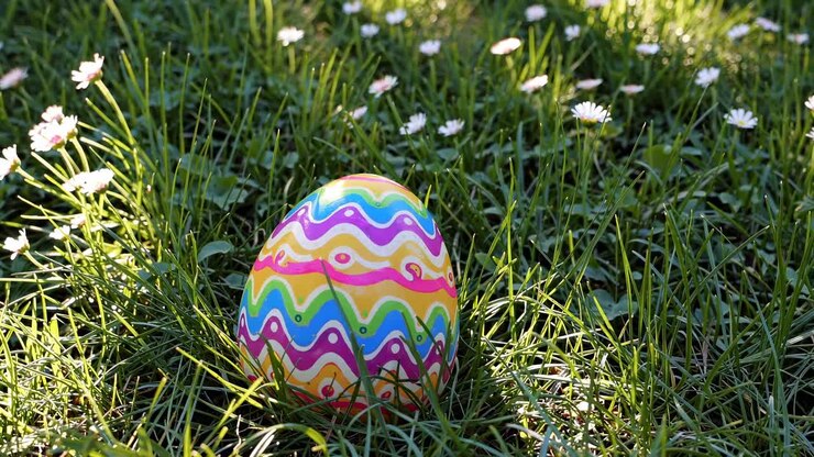 Colorful Easter egg nestled in grass, captured from a low-angle perspective, evoking a playful