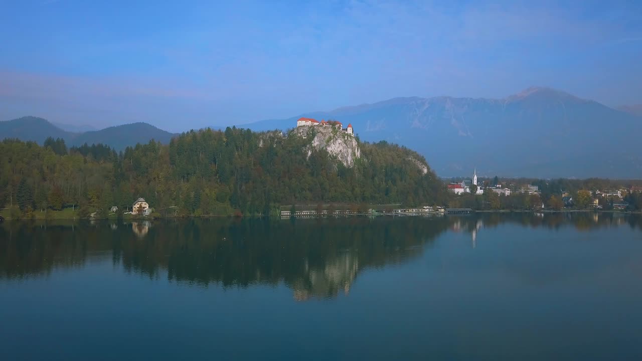 Volando sopra il pittoresco Lago di Bled verso il Castello di Bled in ottobre, quando tutti i vivaci colori autunnali sono al loro meglio.