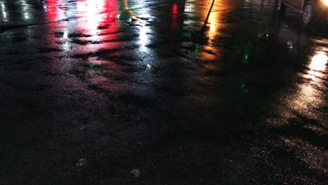 las luces multicolores de la ciudad nocturna se reflejan en el asfalto mojado durante la lluvia. resolución 4k