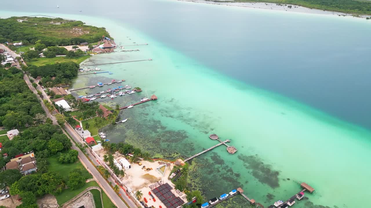 Aerial view of turquoise lagoon and town in Bacalar, Mexico under clear skies