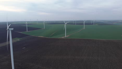 Grandes-Aerogeneradores-Con-Palas-Giratorias-En-El-Campo,-Vista-Aérea