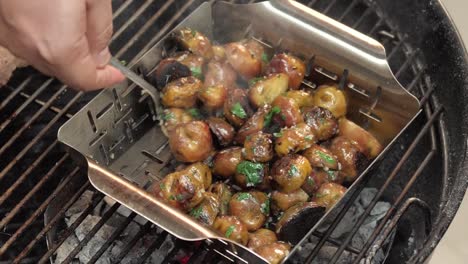 close up, chef stirring grilled and seasoned potatoes over a hot grill, slow motion