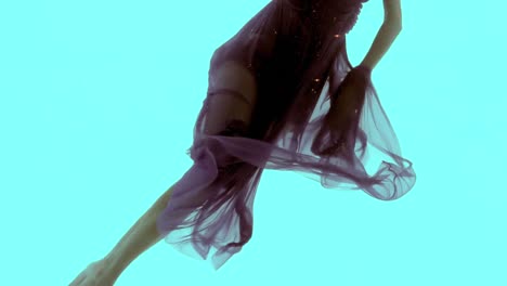 woman with maxi dress swimming underwater