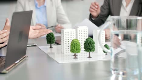 architectural model on the table and architects in the background