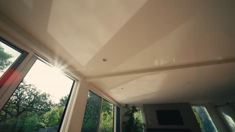 looking up at the ceiling of luxury home with water reflections rippling on the ceiling from the sunlight hitting the water