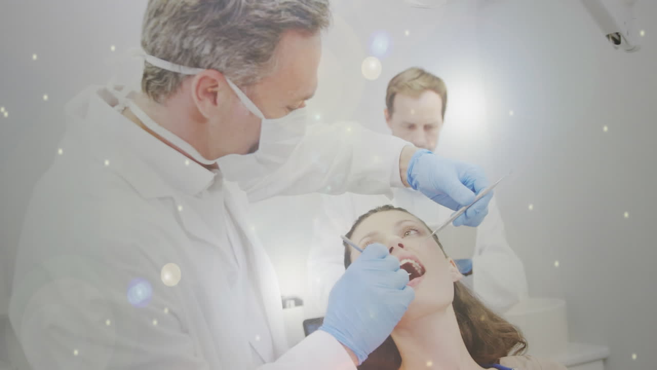 여성 환자를 치료하는 치과의사를 향해 움직이는 빛의 반 ⁇ 이는 반점