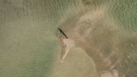 drone ascending with woman spinning at elafonissi beach during summer in crete, greece