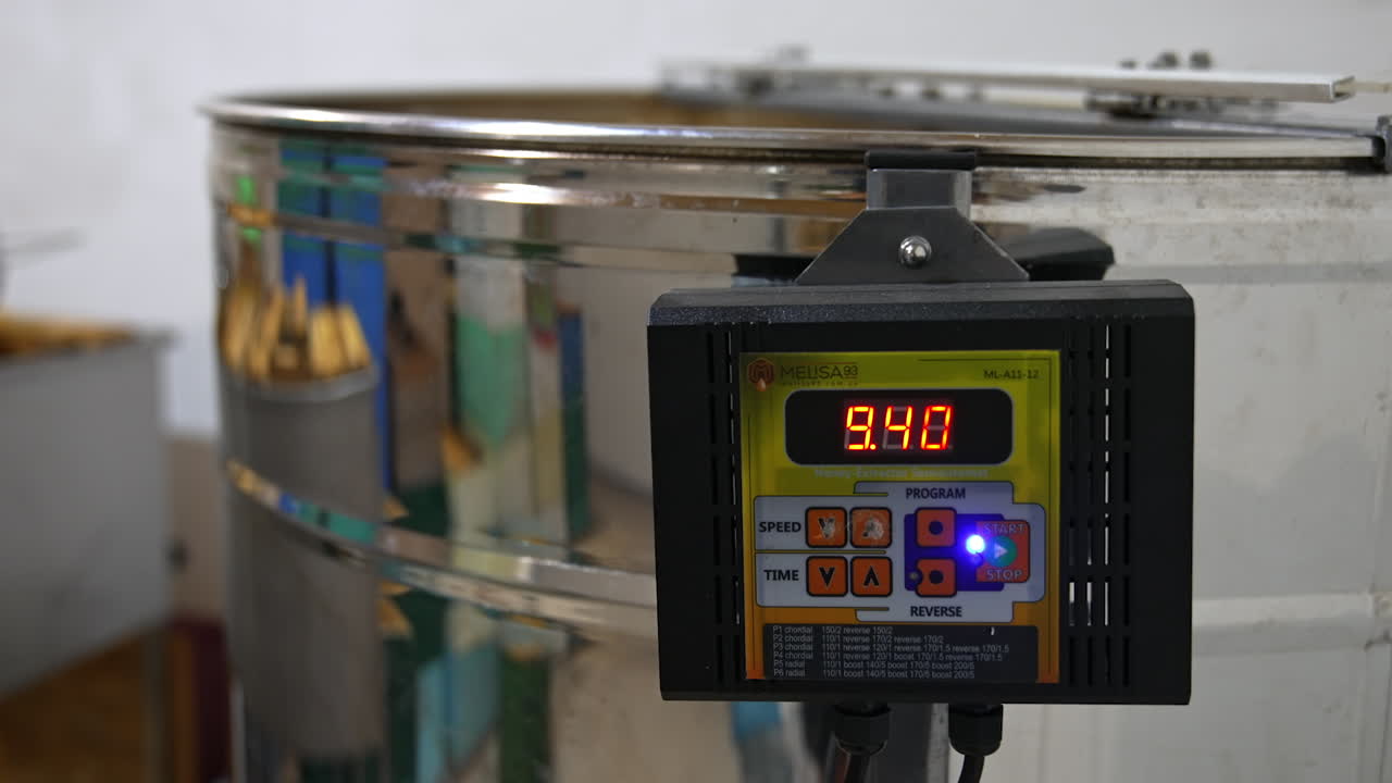 Sensor working on the electric machine for honey extraction. Close up. Equipment for pumping honey in the process of work.