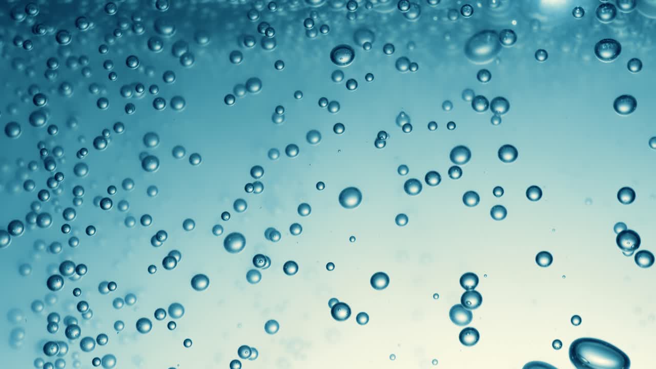 Many water bubbles in blue water close up, abstract water wave with bubbles in slow motion