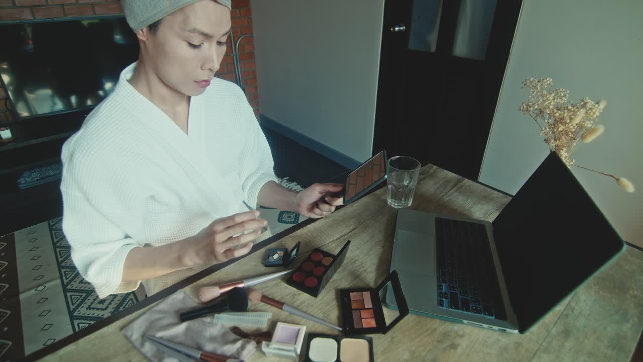 Woman applying makeup at home