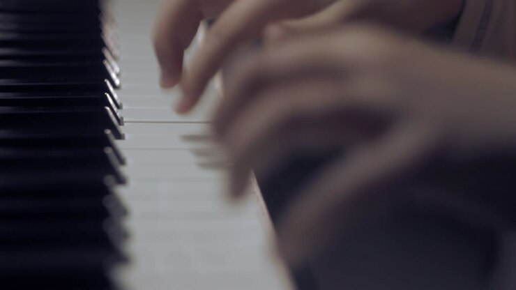 Young boy playing piano, close up of hands