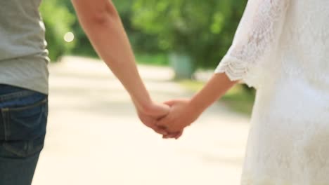 couple walking hand in hand in a park