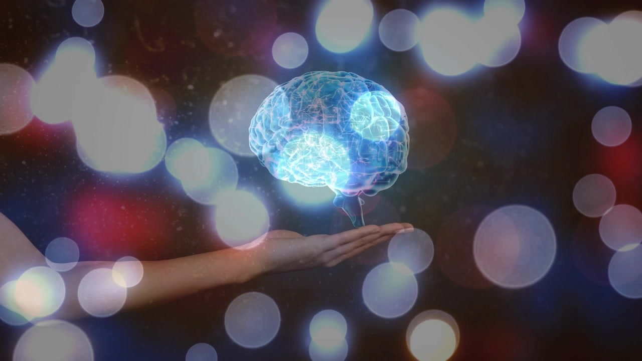 Mano che entra da sinistra, si posiziona e tiene un'orbita che si trasforma in un cervello olografico pulsante, mostrando un'interfaccia neurale.