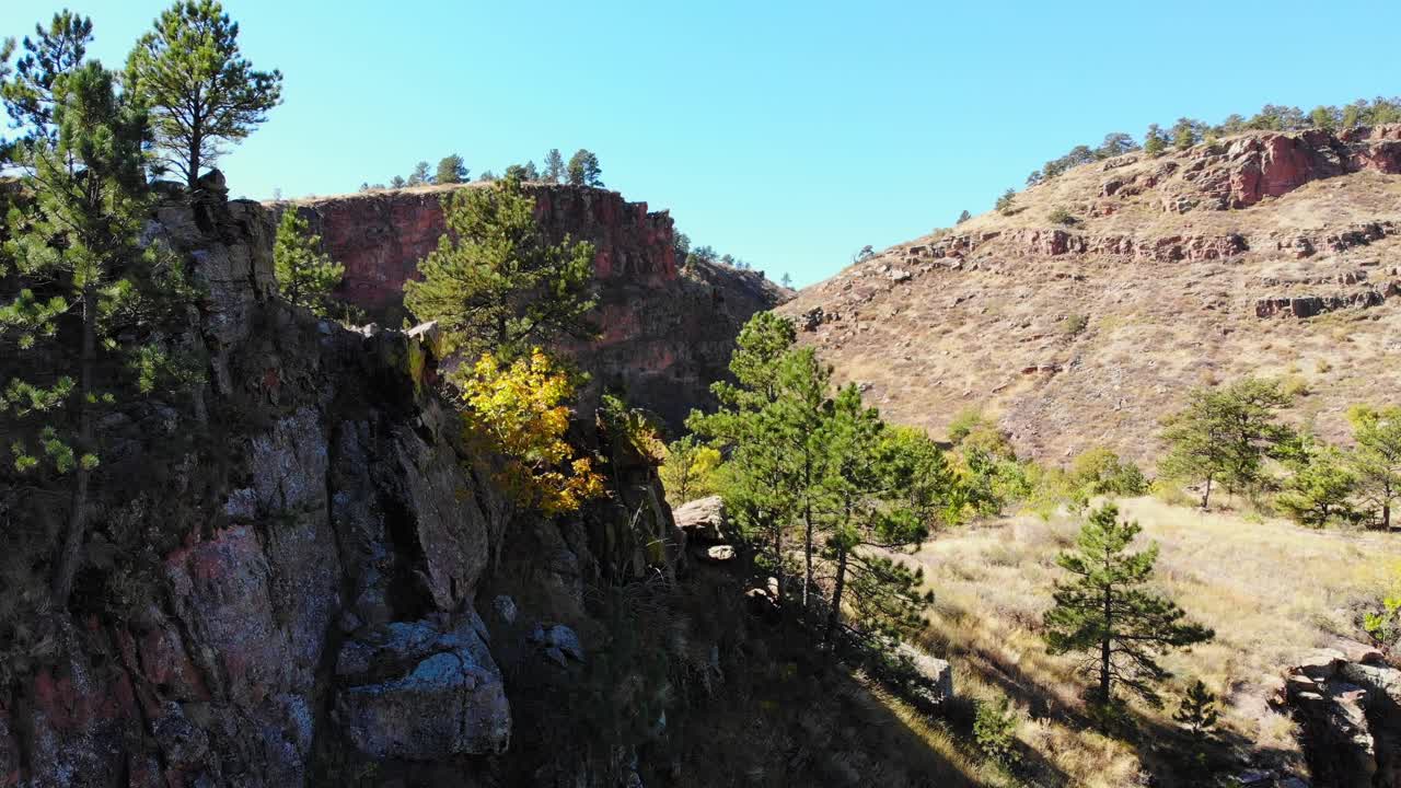 기슭에 녹색 노란색 가을 나무가 있는 바위 언덕과 능선