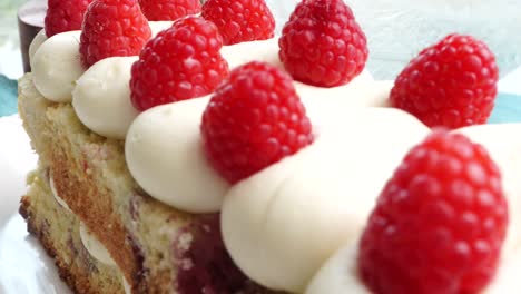 making a dessert called red raspberry tea cake made with fresh berries and vanilla buttercream frosting. great for tea parties. close up panning across the side of the raspberry tea cake