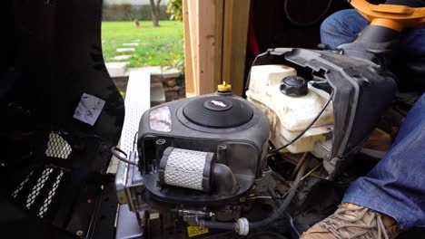 Ride-On-Mower-Close-Up-Under-The-Bonnet-With-Gardener-Adjusting-Idle