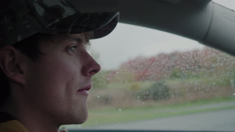 Young-Man-Turns-and-Searches-for-a-Parking-Spot-in-The-Rain---Handheld-Close-Up