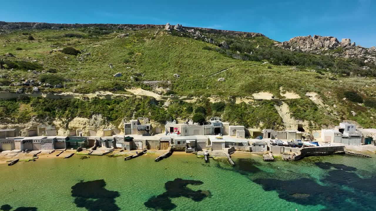 sumergirse en el atractivo rústico de la bahía de gnejna, malta, donde las chozas tradicionales y las arenas prístinas se encuentran con el abrazo del mediterráneo