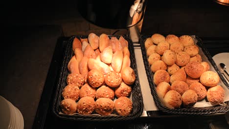 different kinds of mini bread rolls are displayed in warm light