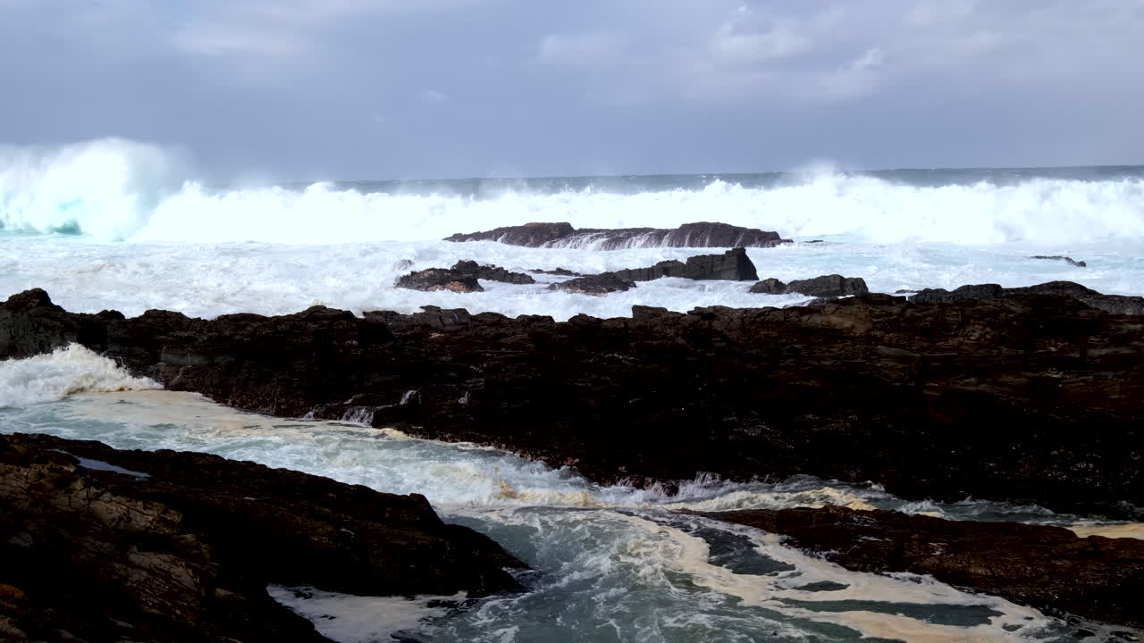 Tempestuous Indian ocean waves crash into rugged Storms River coastline, slomo