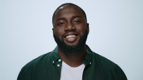 Closeup-african-handsome-guy-smiling-at-camera-in-studio.-Afro-man-posing