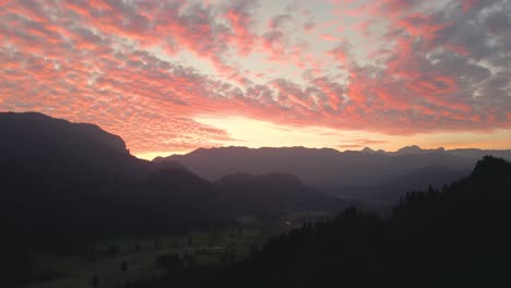 Silhouette-of-mountain-ranges-around-beautiful-valley-under-dramatic-sky-during-golden-hour