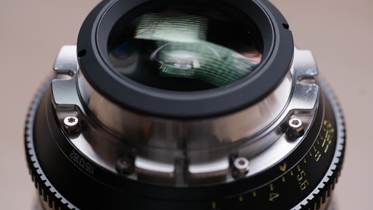 Close-up of hands tightening screws on a freshly installed PL mount on a cinema lens. Final assembly step of an EF to PL conversion. Precise and satisfying technical footage