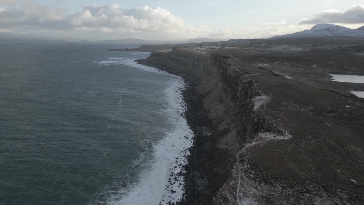 acantilados escarpados de kilt rock bajo cielos nublados a lo largo de la costa de la isla de skye, escocia, con un mar tranquilo