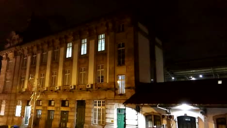 woman walking alone down serene street next to sao bento station in porto at night