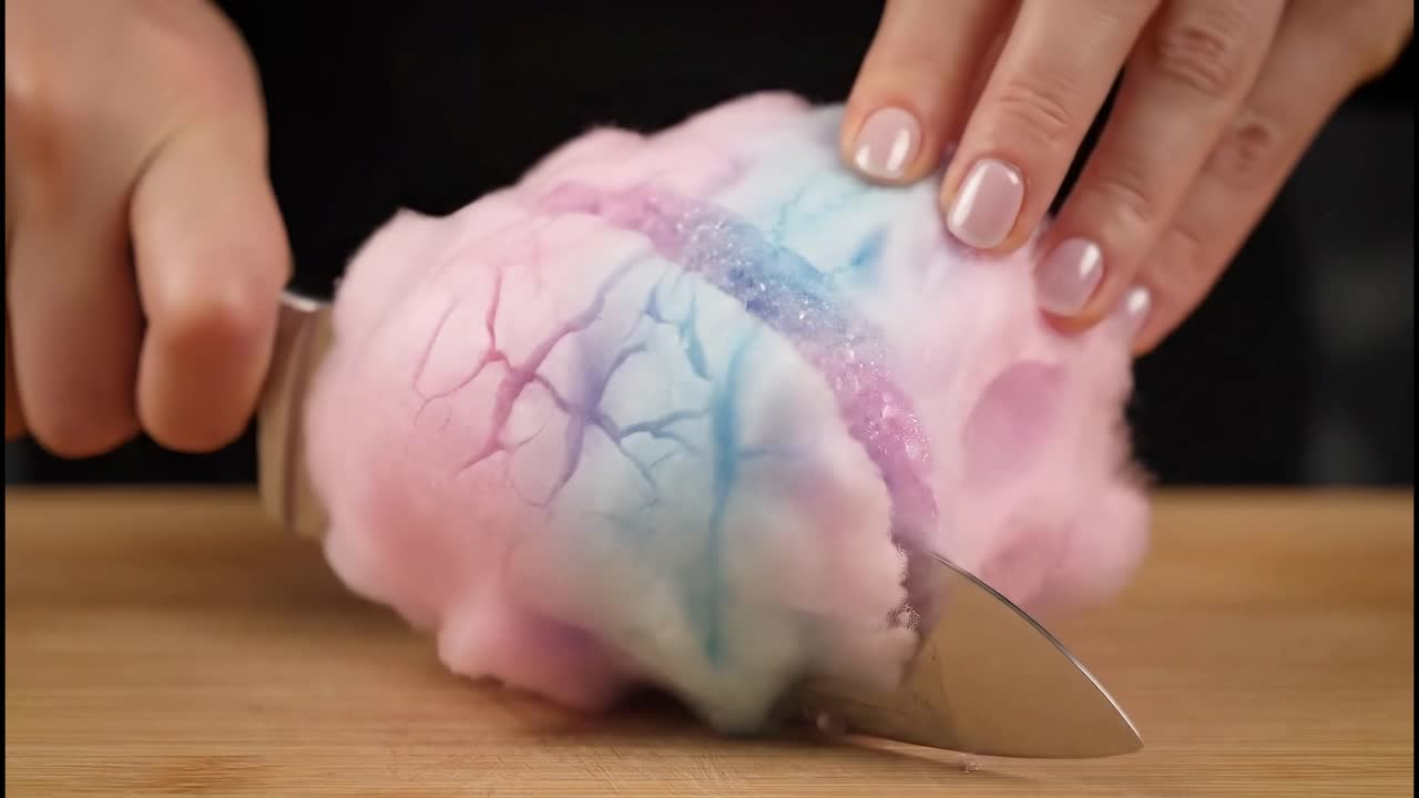 Cutting colorful cotton candy with knife