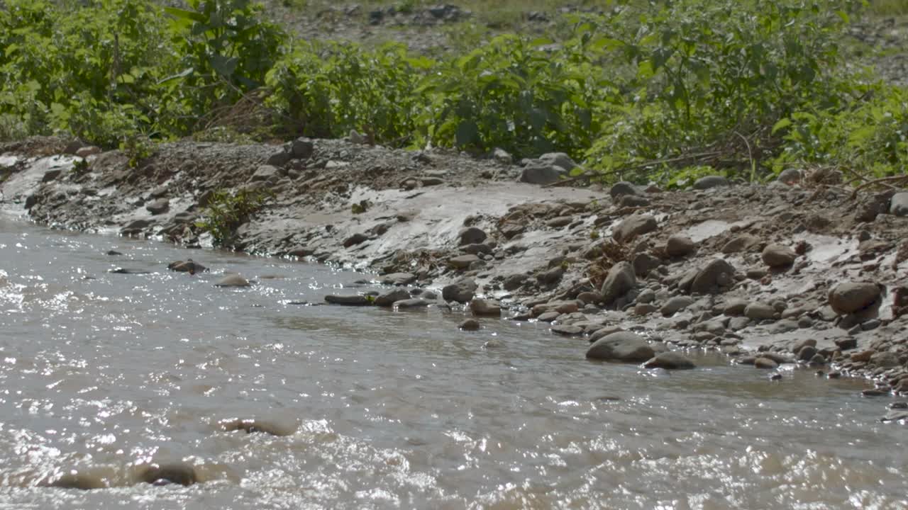 Running river water on a leveled landscape wider view.