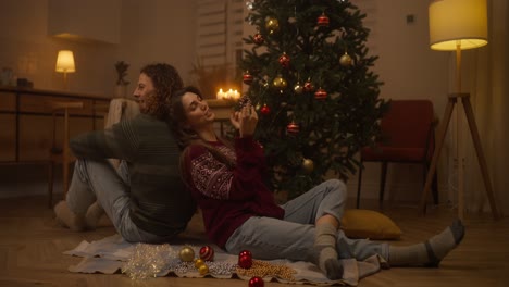 pareja decorando el árbol de navidad en casa