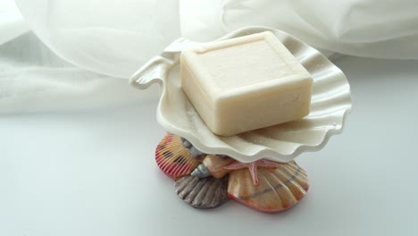 jabón de barra blanca en el plato de jabón de conchas marinas