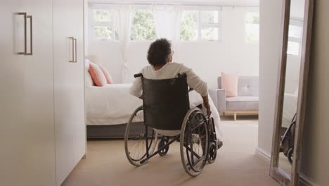 senior mixed race woman sitting on a wheelchair. social distancing and self isolation in quarantine