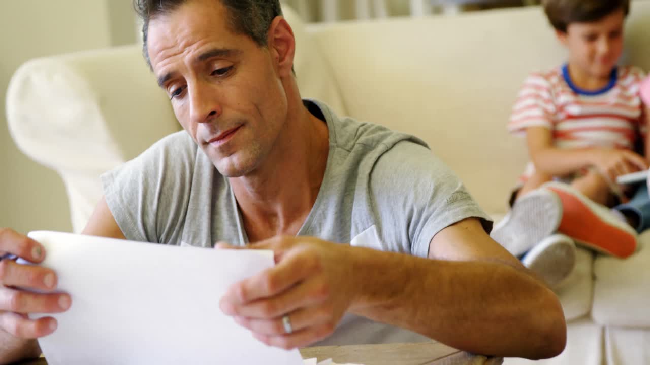 Tense man checking bills in living room