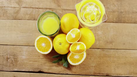 overhead of sweet limes with glasses of juice and juicer