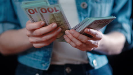 -Close-up-of-a-caucasian-woman-counting-american-paper-money-with-her-hands