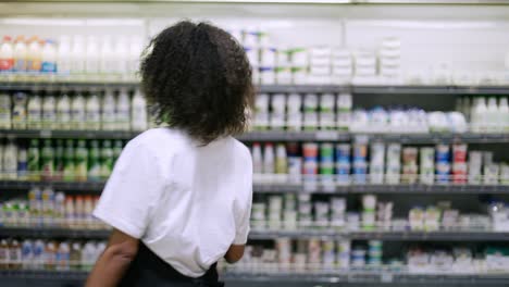 Trabajador-Sonriente-Con-Delantal-Negro-Bailando-En-El-Supermercado,-Divirtiéndose-Durante-El-Trabajo