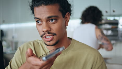 guy talking loudspeaker smartphone in cafe closeup. man recording voice message