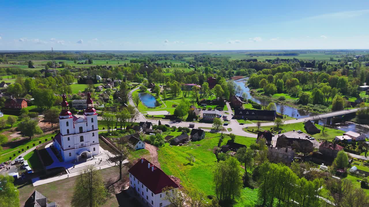 Establishing aerial shot of Christian faith heritage and rural skyline architecture in Lithuania