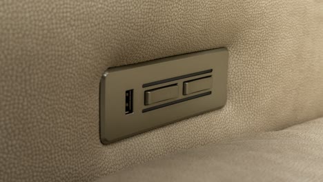 Zoom-Lento-En-El-Panel-De-Control-De-Latón-Del-Sillón-Reclinable-Eléctrico-De-Cuero-Marrón-Claro,-Vista-Lateral