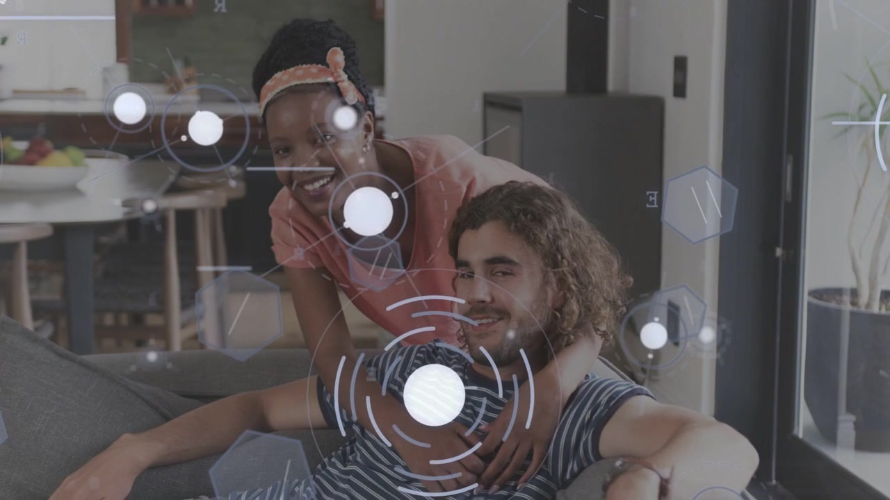 Woman walking in leaning over man reclining home couch HUD showing shoulders sharing love for tech