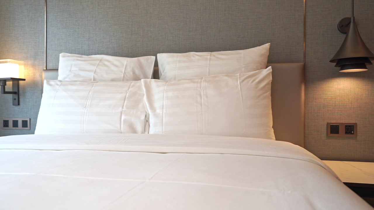 панорамное изображение кровати в гостиничном номере, ожидающей своих следующих обитателей