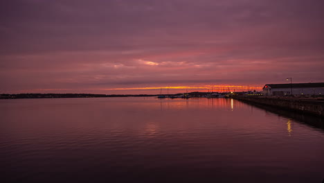 empty port cloudy sunset, dramatic sky on a harbor side of water, still shot timelapse