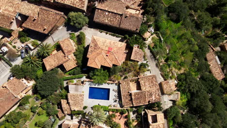 top down aerial pan of luxury villas in spanish mountain town deia