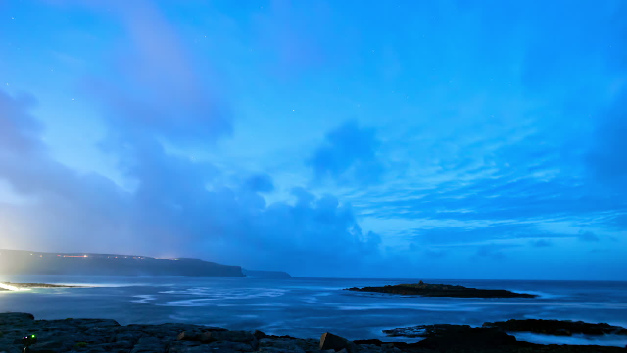 Timelapse shot at night from Doolin Pier captures Cliffs of Moher in the distance and swirling tidal currents around Crab Island