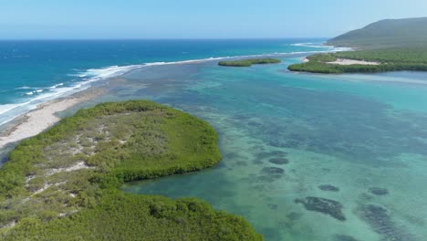 aerial establishing shot of turquoise water lagoon with caribbean sea and tropical islands.sunny day with blue sky and reaching waves. wide shot. sunny day in summer. playa caobita, dominican republic