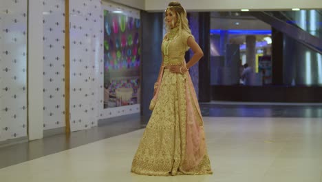 a beautiful young woman wearing traditional indian attire stands indoors