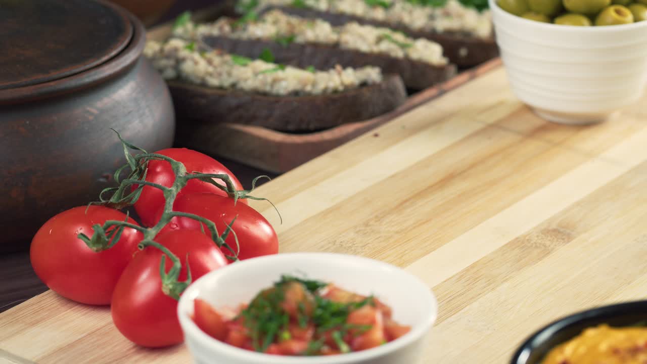 cocina israelí. manos poniendo shakshuka decorada con perejil de primer plano. plato nacional judío hecho de huevos fritos en salsa de tomate, pimientos picantes, cebollas y especias, cultura de oriente medio